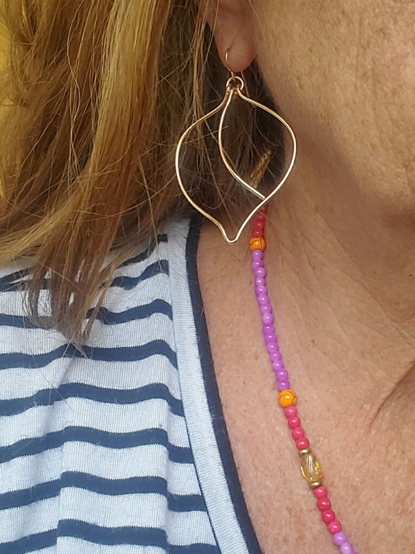 wire leaf earrings being worn with striped top